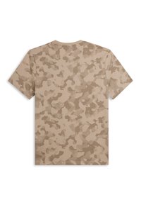 Camiseta de camuflaje beige con mangas cortas, que presenta un patrón texturizado de diferentes tonos de marrón y beige en toda la tela.