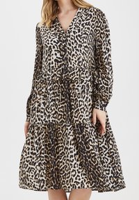 Klänning i leopardtryck i lätt material, med lagerdesign, långa ärmar och v-ringning. Färgerna inkluderar beige, svart och brunt.