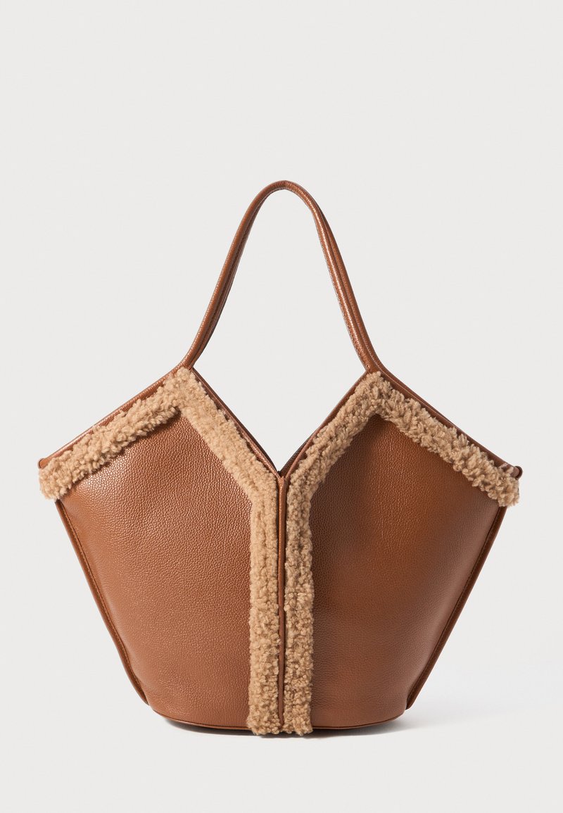 Brown leather handbag with tan shearling trim outlining a geometric shape, featuring a single rounded handle.