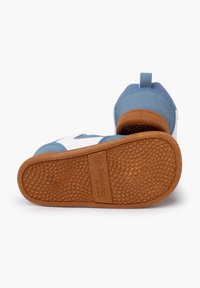Sneaker blu e bianco con suola in gomma marrone texture. Presenta una finitura liscia e un tassello posteriore per una facile vestibilità.