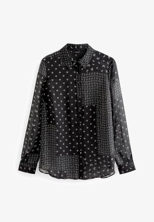 Sort gennemskinnelig bluse med knapper med blandede hvide geometriske mønstre, herunder polkaprikker, zigzagmønstre og halvcirkler, lange ærmer og krave.