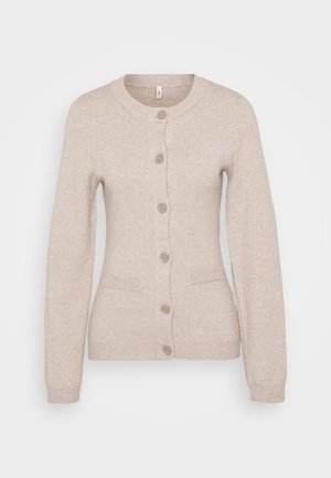 Šviesiai kreminės spalvos megztinis, turintis apvalų iškirpimą, šešis sagas, dvi priekines kišenes ir raštuotas rankogalius bei apatinę dalį.