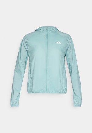Chaqueta ligera con capucha en verde menta. Cuenta con un cierre completo, puños elásticos y un pequeño logotipo en el pecho. Textura suave.