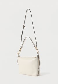 Beez nahkt õlakott kuldse riistvara, reguleeritava rihma, ruudukujulise kuju ja sileda tekstuuriga. Lukuga sulgemine õrnade külgaktsentidega.