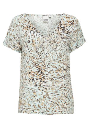 Lühikeste varrukatega helesinise pluusi, millel on pruunide ja mustade keerdus loomamustrid, sügava V-kaeluse ning pehme, tekstuurse kangaga.