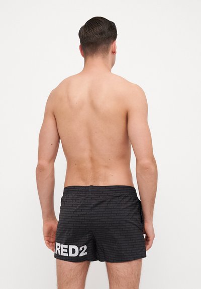 Shorts de bain noirs avec un motif texturé, arborant un logo "RED2" blanc sur le côté. Fabriqués à partir d'un matériau léger et à séchage rapide.