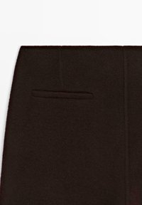 Ciemnobrązowe wełniane spodnie z pojedynczą wpuszczaną kieszenią i gładką fakturą, o czystych liniach i dopasowanym kroju.