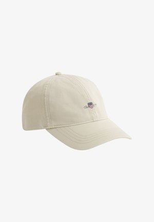 Casquette de baseball beige avec une visière incurvée et un petit logo brodé sur le côté droit à l'avant.