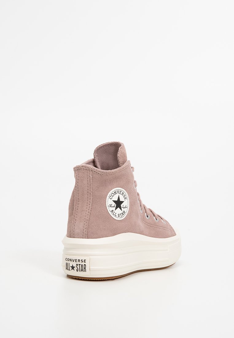 Sneakers alte in suede rosa Converse All Star con suole in gomma bianca, occhiali metallici e un patch rotondo con il logo sul lato.