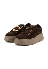 Sneaker platform in suede marrone con dettagli floreali decorativi e design con lacci. Presenta occhielli in tonalità oro e suola in gomma texturizzata.