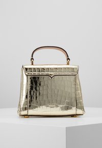 Złota metaliczna torebka o gładkiej fakturze w wzór krokodylej skóry, o sztywnej formie i krótkim, brązowym skórzanym uchwycie. Złote akcenty metalowe.