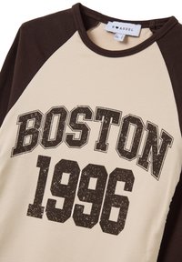 Creme- und braunfarbener T-Shirt mit Raglanärmeln, versehen mit dem Aufdruck "BOSTON 1996" in abgenutztem Schwarz. Aus Baumwollmaterial, mit glatter Textur.