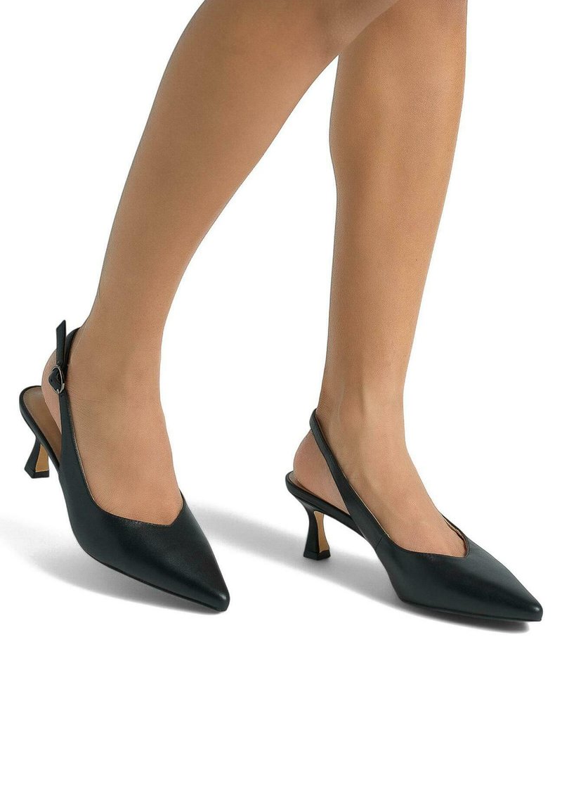 Scarpe slingback in pelle nera con punta affilata, tacco basso e una sottile cinghia alla caviglia con fibbia. Texture liscia senza motivi visibili.