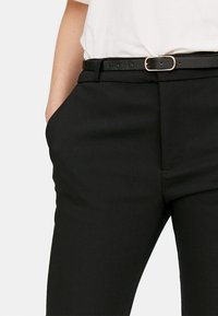 Zwarte op maat gemaakte broeken met een slank ontwerp, voorzien van zijzakken en een smalle riem met een gouden gesp voor een mooi detail.