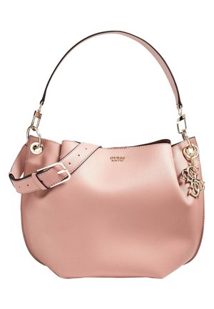 Sac à main en cuir rose avec une large bandoulière, une boucle dorée et un charm avec le logo de la marque en or suspendu sur un côté.