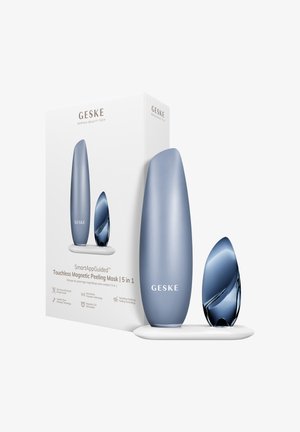 Elegant blåtgråt GESKE berøringsfrit magnetisk peelingmaskine og applikator på hvid stander med produktæske, der viser mærke og funktioner.