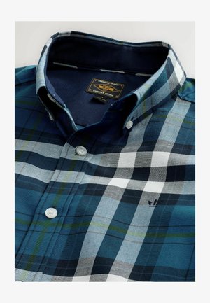 Koszula w kratę w odcieniach niebieskiego, zielonego i białego; ma kołnierzyk zapinany na guziki, białe guziki i małe naszywane logo w okolicy klatki piersiowej.