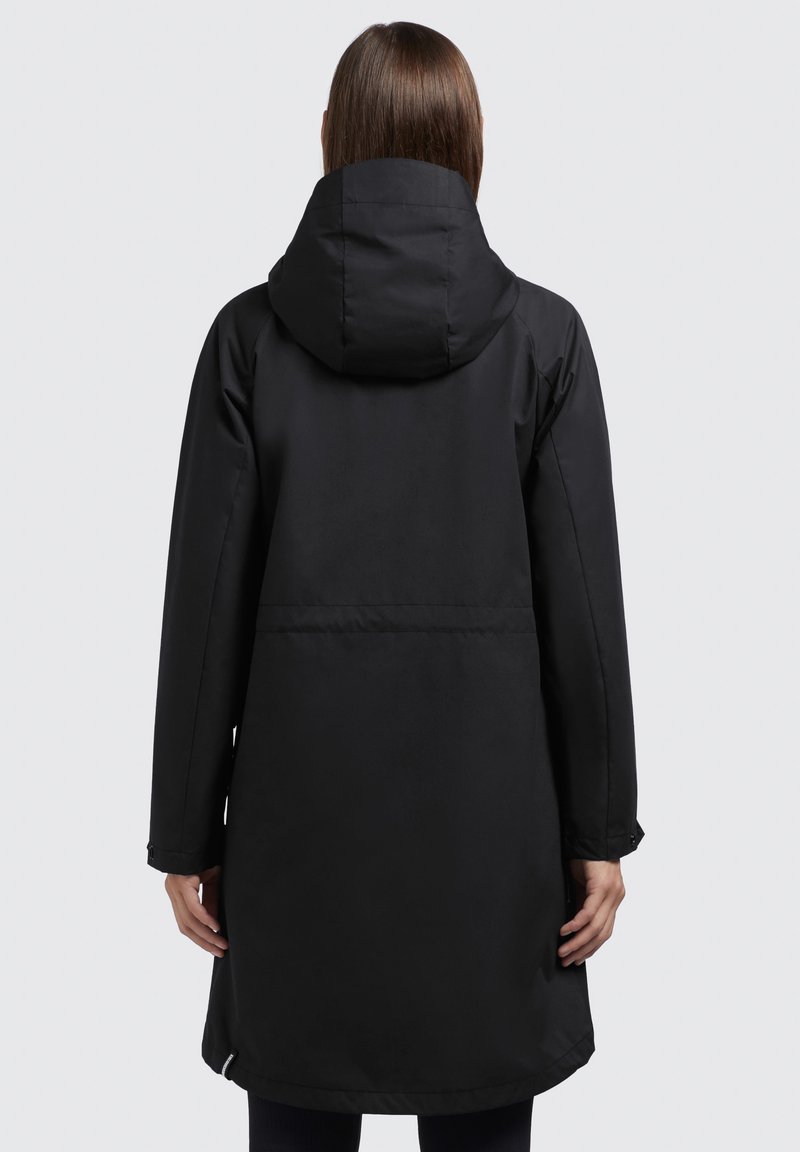 Parka noire imperméable avec capuche, manches longues et coupe droite. Présente une texture lisse et une taille cintrée à l'arrière.