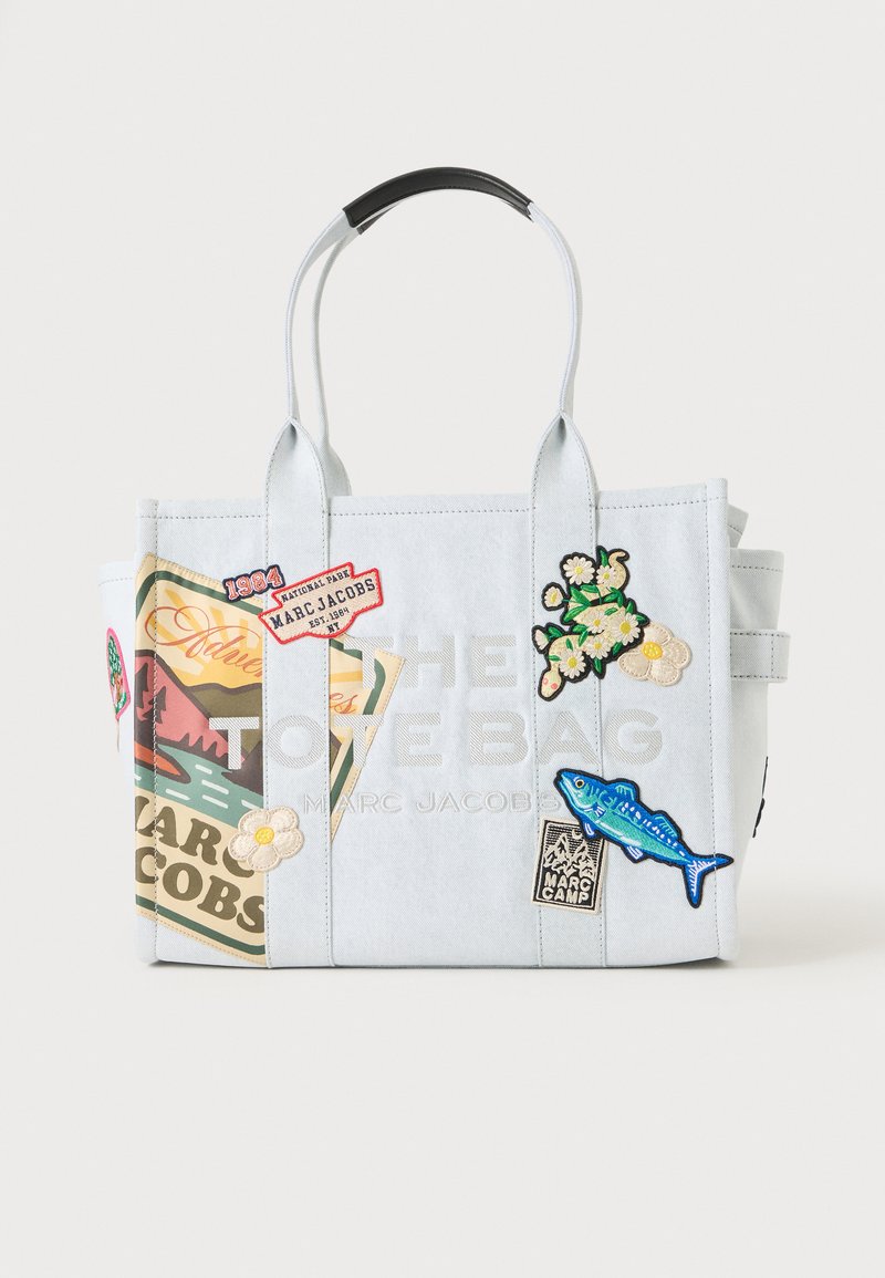 Sac cabas bleu clair Marc Jacobs décoré de patchs, dont des fleurs, un poisson, une scène de montagne et divers motifs de logos.