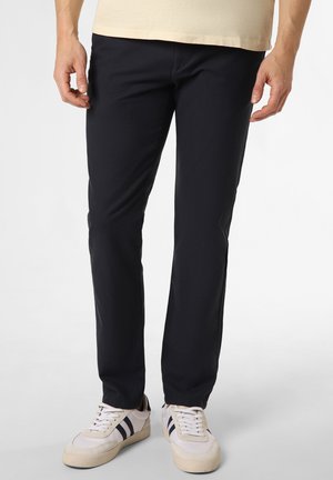 Marineblaue Slim-Fit-Hosen aus strukturiertem Material mit Fronttaschen. Tragen mit weißen Sneakers, die marineblaue und beige Akzente haben.