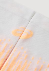 Synthetic fabric in white with an orange gradient pattern. Features a smooth texture and an orange logo near the seam.