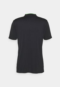 Musta lyhythihainen t-paita, jossa on pyöreä kaulus ja vihreä yksityiskohta. Liukas kangas ja koristelematon muotoilu, suunniteltu arkikäyttöön.