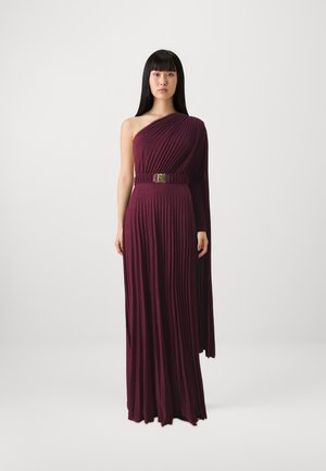 Vestito bordeaux a spalla unica con pieghe verticali, dotato di una cintura e di una lunga manica drappeggiata. Texture liscia con dettagli scintillanti.