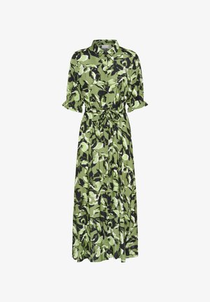 Robe longue verte avec un motif de feuilles noir et blanc. Dotée d'un col, de manches courtes bouffantes et d'un détail de taille liée.