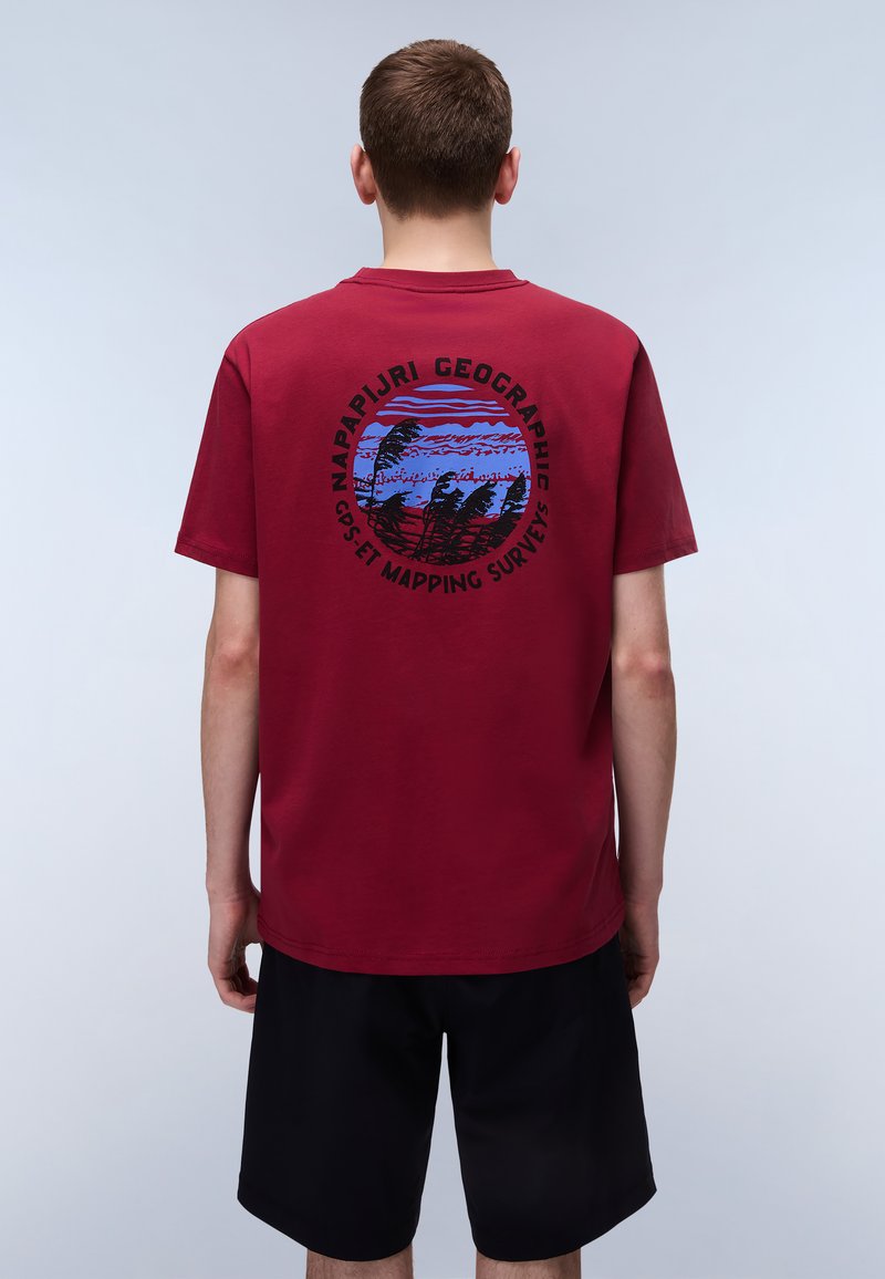 Bordeaux katoenen t-shirt met een ronde graphic op de achterkant, die bomen en bergen in blauw en zwart afbeeldt, met de tekst "Napapijri Geographic".
