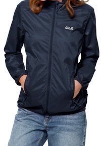 Mörkblå lättviktsjacka i slätt, vattenavvisande material. Har dragkedja framtill, elastiska muddar och sidofickor. Märkeslogotyp visas.