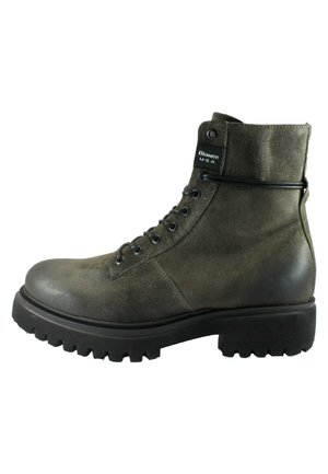 Stivale alla caviglia in suede verde con punta arrotondata, chiusura a lacci e suola di gomma nera spessa con scanalature profonde. Accentuato da un'etichetta con logo.