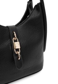 Borsa a tracolla nera in pelle sintetica con superficie texturizzata, forma curvata e dettaglio della chiusura in tono oro sulla tracolla.