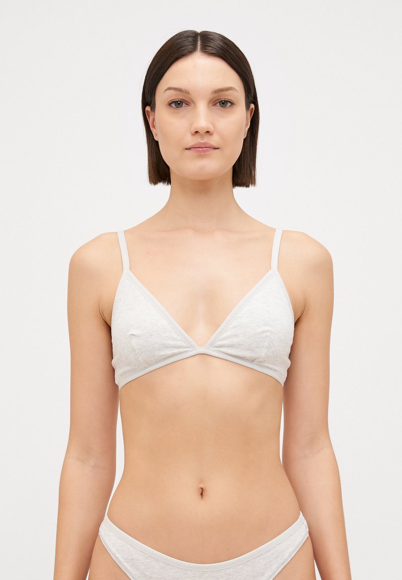 Lichtgrijze driehoekige bralette met dunne banden, gemaakt van zachte stof, met een gladde textuur en minimalistisch ontwerp.