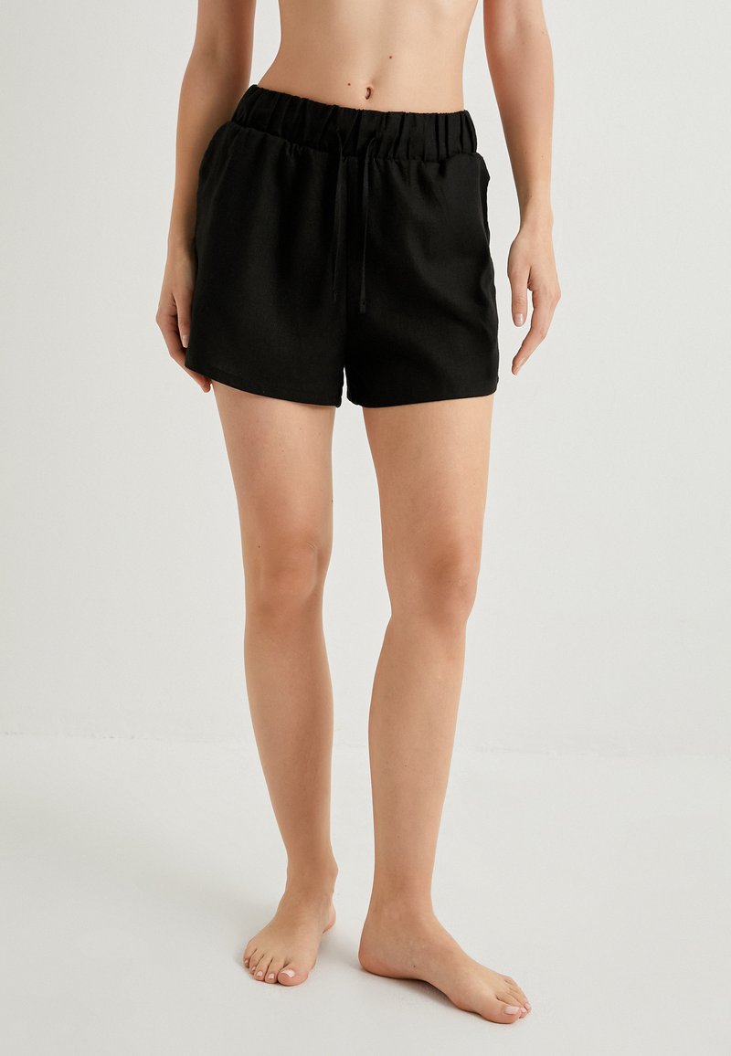Sorte shorts med snøre i et let stof, elastisk talje og sidelommer; afslappet og løs pasform.