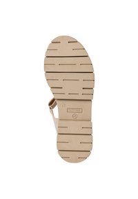 Beige sandal sole with textured rubber, featuring multiple tread grooves for grip. Designed with a rounded heel and subtle branding.