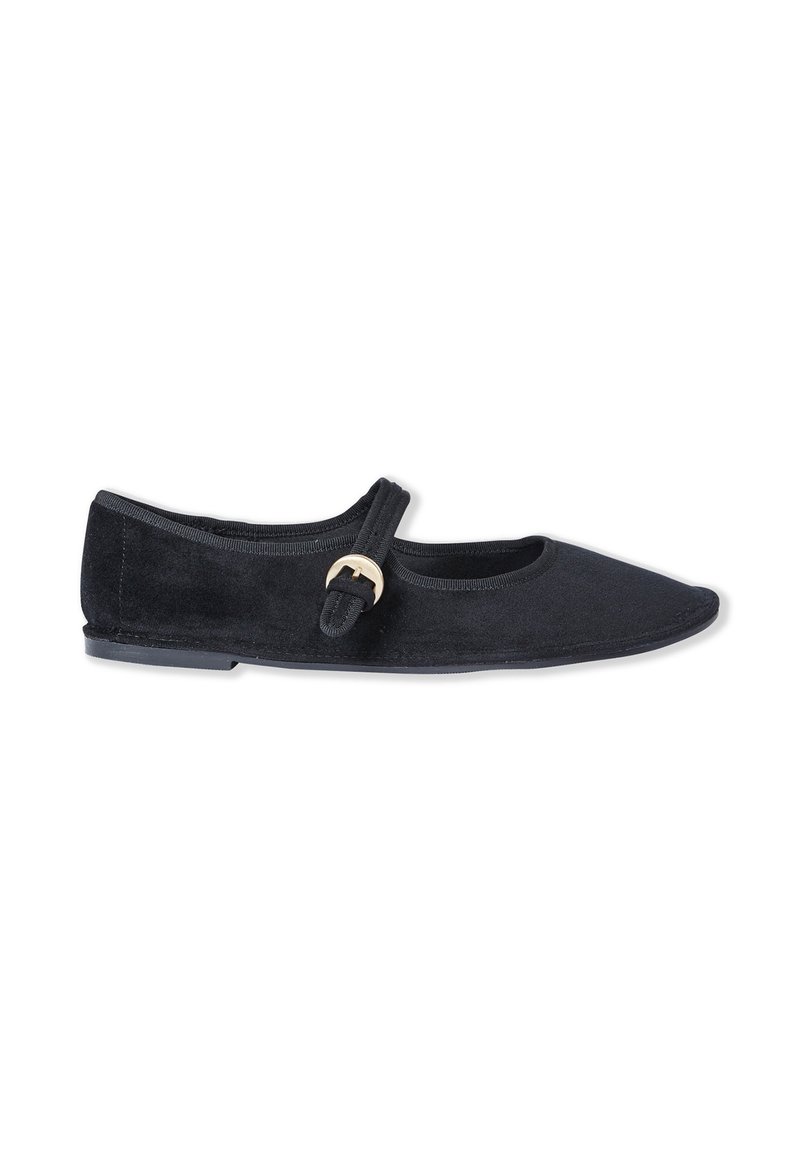 Black suede flat shoe with a rounded toe and slight heel. Features a strap closure with a circular metal accent. Smooth texture.