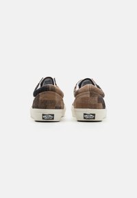 Brune rutete joggesko med myk tekstur, polstret krage og hvite gummisåler. Har Vans-logo på hælen.