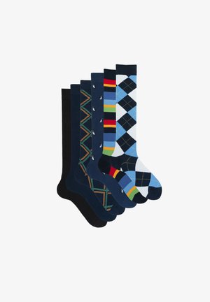 Sechs Paar Socken in verschiedenen Mustern. Merkmale sind einfarbig marineblau, Argyle, Streifen und geometrische Designs. Die Materialien scheinen aus einer Baumwollmischung zu bestehen.