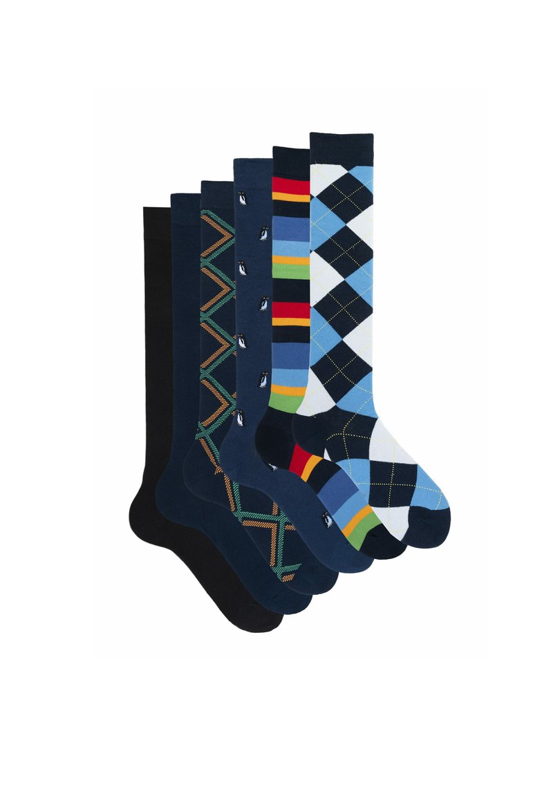 Sei paia di calze con motivi differenti. Le opzioni includono colore solido blu navy, argyle, righe e disegni geometrici. I materiali sembrano essere un misto di cotone.