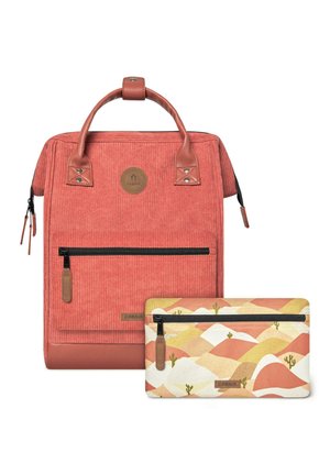 Coral corduroy backpack with brown leather accents, a front zip pocket, and a detachable patterned pouch featuring mountains and cacti.