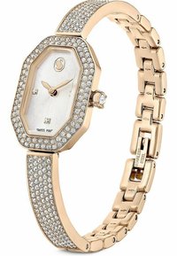 Złocisty ośmiokątny zegarek z białą, teksturowaną tarczą, diamentowymi akcentami i bransoletą wykonaną z kryształów. Widoczny detal z zapięciem ze stali nierdzewnej.