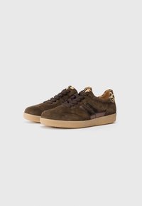 Baskets en daim marron avec des lacets marron foncé, accents en imprimé léopard au talon, et une semelle en caoutchouc marron clair.