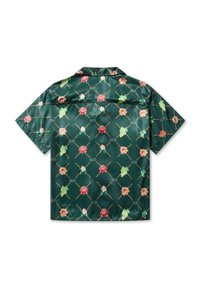 Camisa de manga corta en tejido verde brillante, con un patrón floral de rosas rosas y blancas, y acentos textuales en un diseño de cuadrícula.