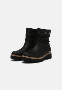 Botas de cuero negras hasta el tobillo con un diseño arrugado, herrajes decorativos y una costura en tono marrón. Presenta una suela rugosa y texturizada.