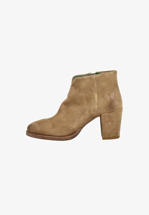 Bottine en daim marron avec talon bloc et fermeture éclair latérale, design simple avec légère décoloration près du talon.