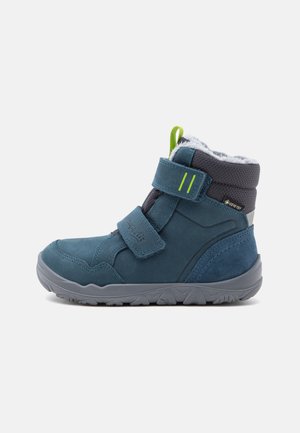 Blå børnevinterstøvle med grå sål, to velcrobånd, grøn træktab, blødt indre foer og Gore-Tex label.
