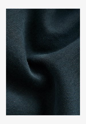 Textured dark blue fabric with a ribbed pattern, showing folds and creases that highlight its smooth surface and depth.