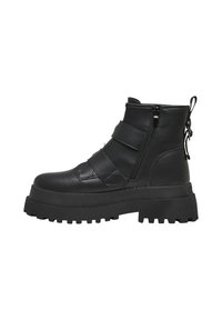 Bottes cheville en cuir noir avec semelle en caoutchouc épaisse, dotées de deux fermetures éclair et de sangles ajustables sur le médio-pied. Accents texturés inclus.