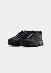 Pair of black and gray trail running shoes with rugged soles and quick-lace system, angled to show front and side details.