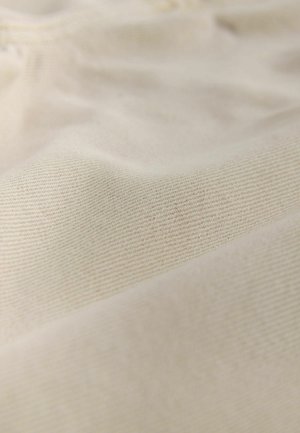 Svijetlo kremasta tkanina s mekanom, teksturiranom površinom koja ima suptilan uzorak dijagonalnog tkanja. Materijal izgleda lagano i glatko.